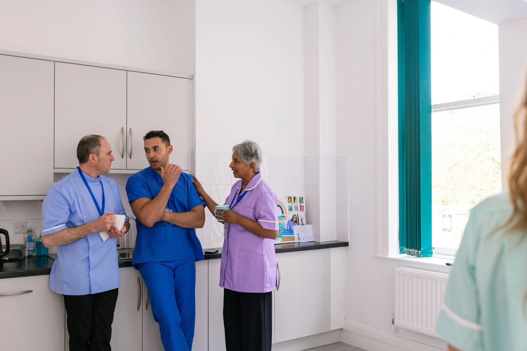 Healthcare professionals standing together in a staff room